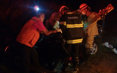 Carreta carregada com eucalipto tomba em cima de veículo que estavam mãe e filho