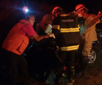 Carreta carregada com eucalipto tomba em cima de veículo que estavam mãe e filho